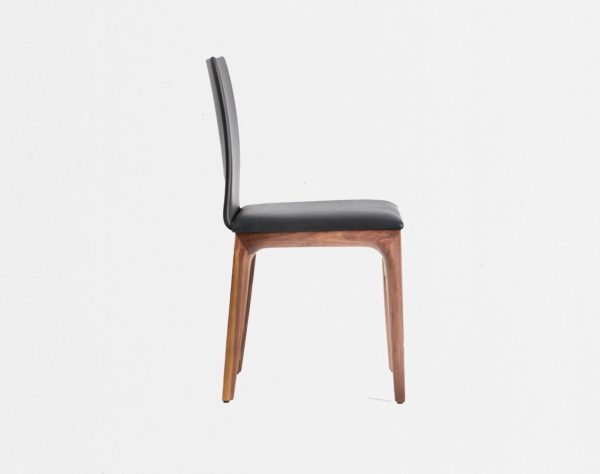 Seitenansicht bequemer Designerstuhl auf Massivholz Gestell in Leder mit gepolsterter Sitz- und Rückenlehne